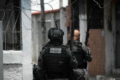 Militariy police officers patrol during the Operacao Contencao (Operation Containment) at the Vila Cruzeiro favela, in the Penha complex, in Rio de Janeiro, Brazil, on October 28, 2025. At least 2,500 security forces agents took part in an operation to arrest drug traffickers from the Comando Vermelho (CV), which resulted in 18 suspects and several police officers dead. (Photo by Mauro PIMENTEL / AFP)
